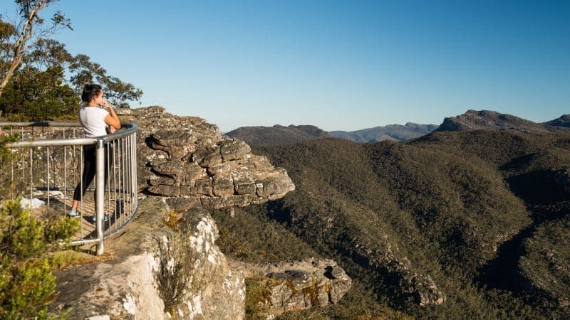 Woman enjoys breathtaking views of Grampians peaks from scenic lookout during a 1 Day Grampians Eco Wilderness Escape tour.