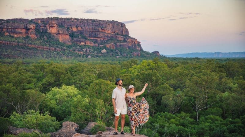 A couple explores rocky terrain at sunset on a 5 Day Kakadu, Katherine Gorge & Litchfield 4WD Adventure departing from Darwin.