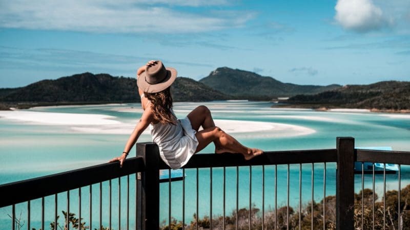 a girl in a sundress and hat at the hillinlet viewpoint overlooking a river delta with sand formations