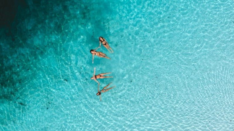 A group of friends floating in the clear waters of Lake Mckenzie